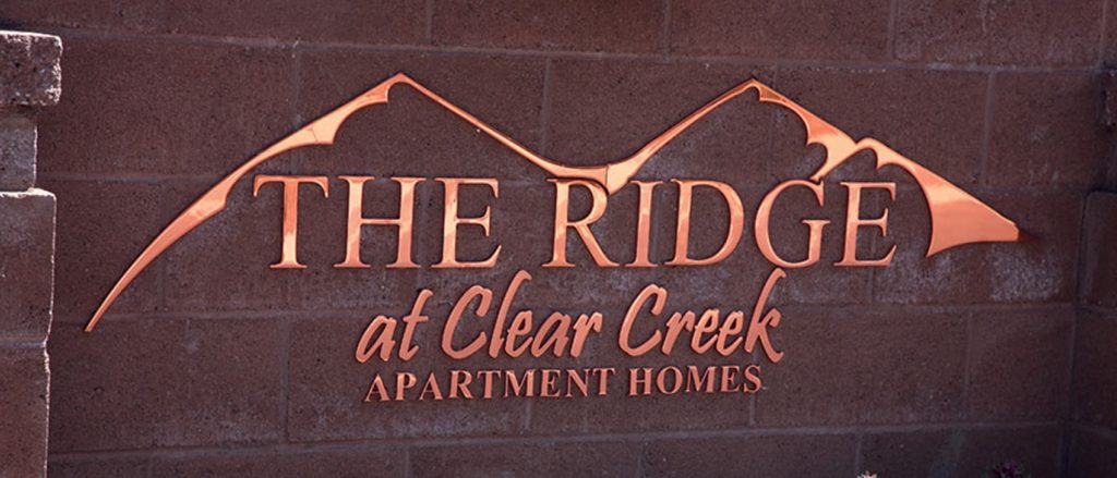 mirror polished flat cut copper metal logo outside neighborhood