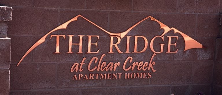 mirror polished flat cut copper metal logo outside neighborhood