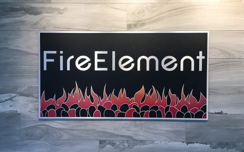 Cast aluminum plaque with painted black background and red flames in a company showroom lobby