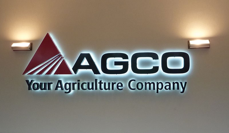 Custom backlit sign with custom triangle logo on white wall