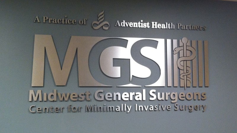 brushed stainless on foam letter sign on a dark gray interior wall