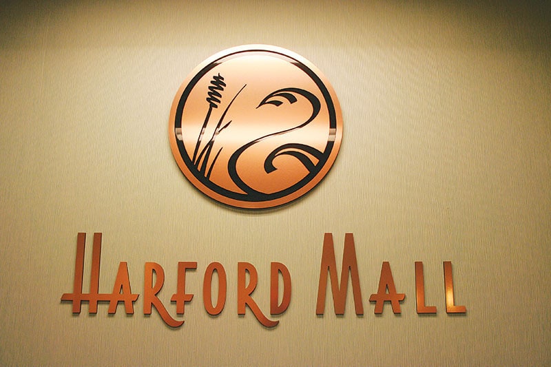 Custom copper sign with custom logo on tan wall