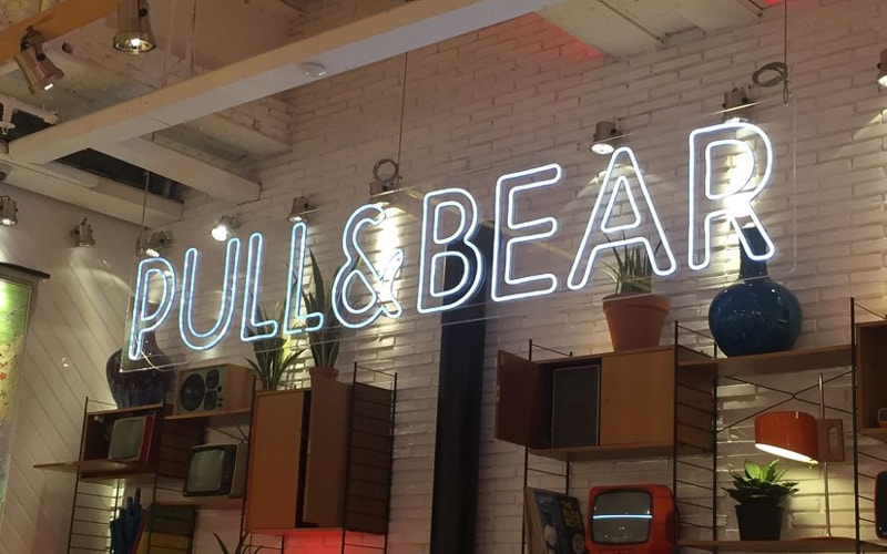 interior LED sign with white LEDS hanging in front of white brick wall